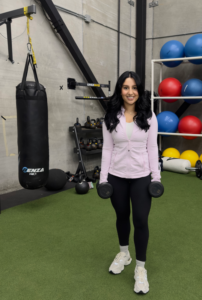 The coach is holding the dumbbells.